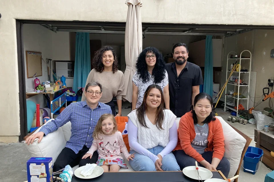 Members of the Zeiger Lab sitting around an outdoor fireplace at a lab holiday party