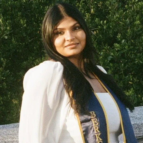 Sravya standing outside with graduation sash from UC Berkeley