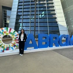 Madelynn standing outside next to a sign for the ABRCMS conference