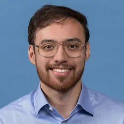 Ryan Carney in front of a blue background